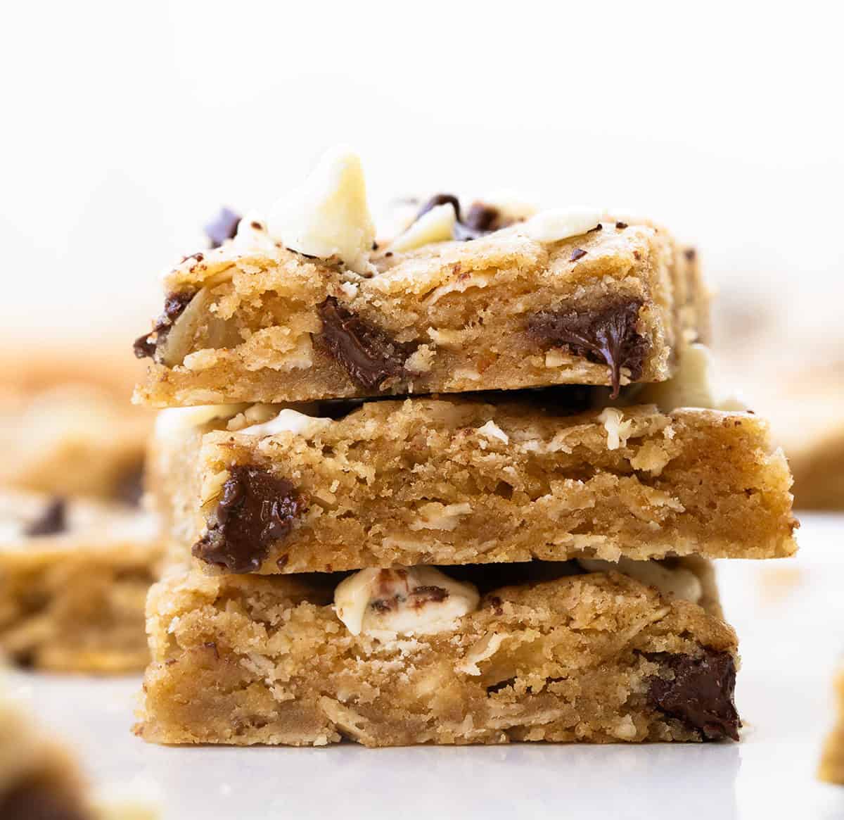 Small stack of Sheet Pan Marry Me Cookie Bars on a white table Small stack of Sheet Pan Marry Me Cookie Bars on a white table.