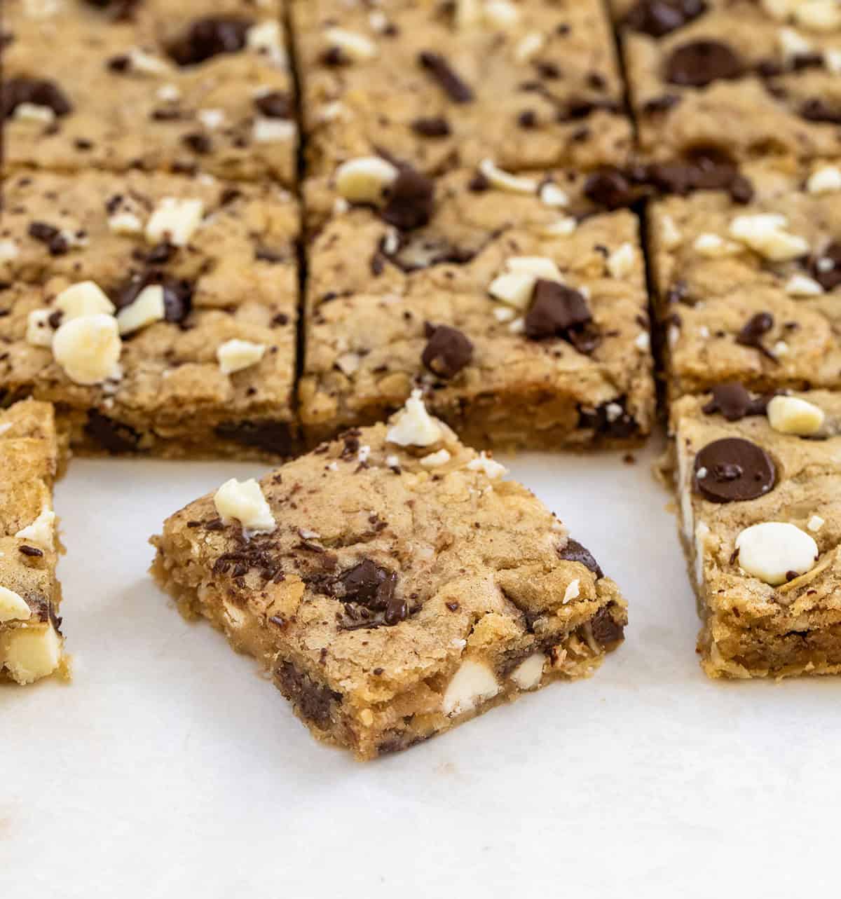 Sheet Pan Marry Me Cookies cut into squares on a white table and one on an angle Sheet Pan Marry Me Cookies cut into squares on a white table and one on an angle.