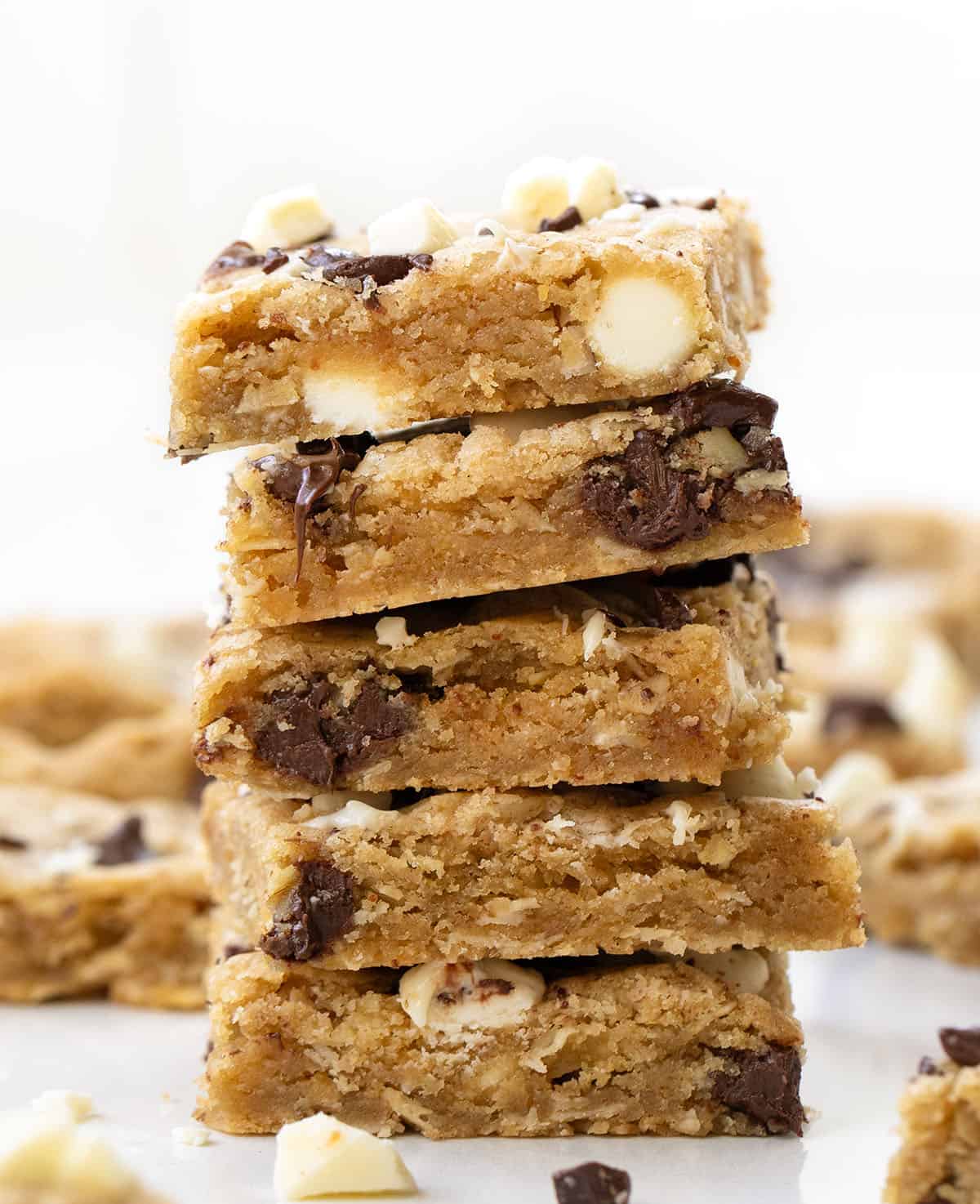 Stack of Sheet Pan Marry Me Cookies on a white table surrounded by more bars Stack of Sheet Pan Marry Me Cookies on a white table surrounded by more bars.
