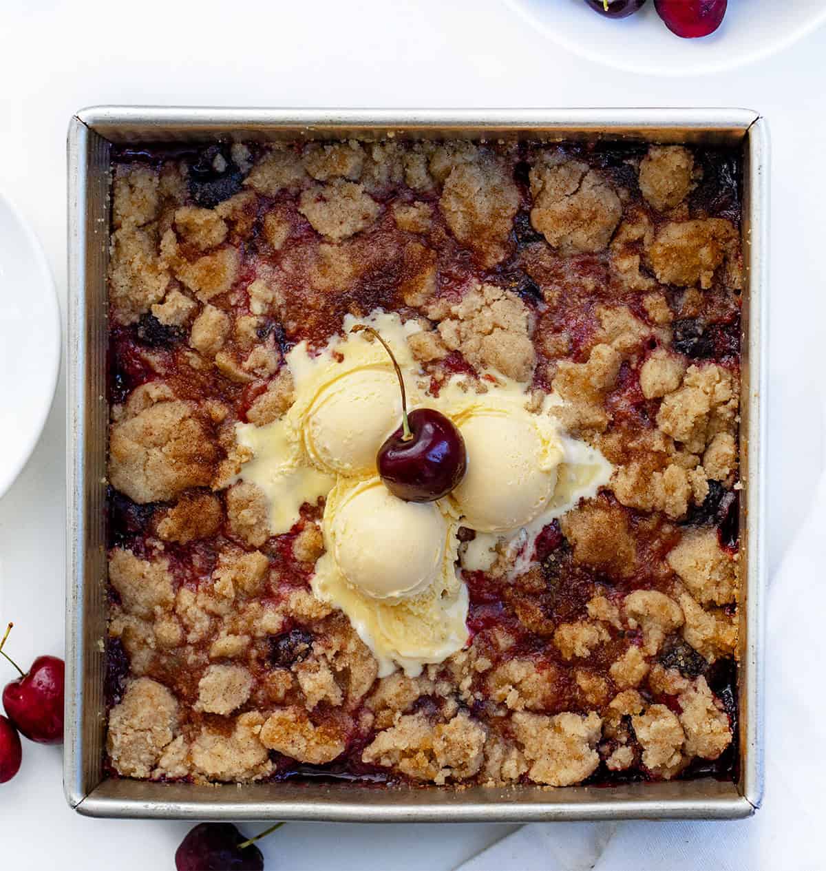 Square pan of Snickerdoodle Cherry Cobbler on a white table from overhead.
