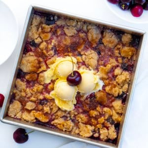 Square pan of Snickerdoodle Cherry Cobbler on a white table from overhead.