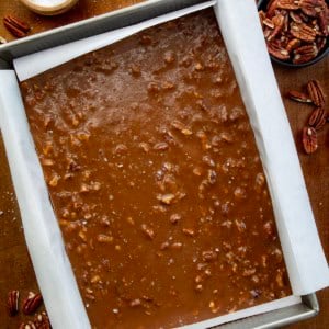 Pan of Soft Salted Pecan Caramels on a wooden table from overhead.
