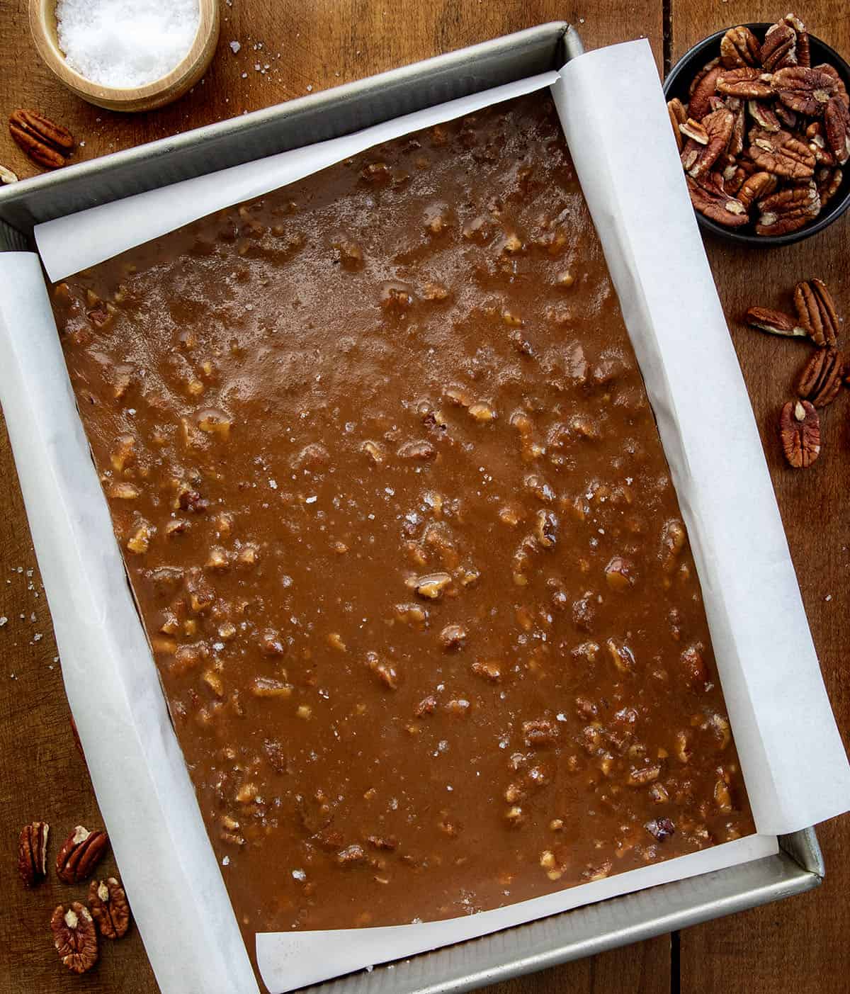 Pan of Soft Salted Pecan Caramels on a wooden table from overhead.