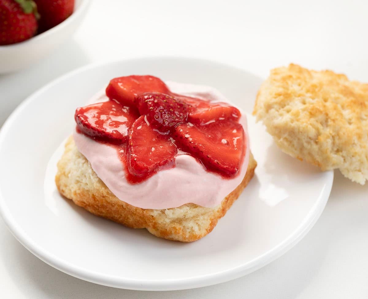 Strawberry Shortcake with Strawberry Stabilized Whipped Cream being assembled.