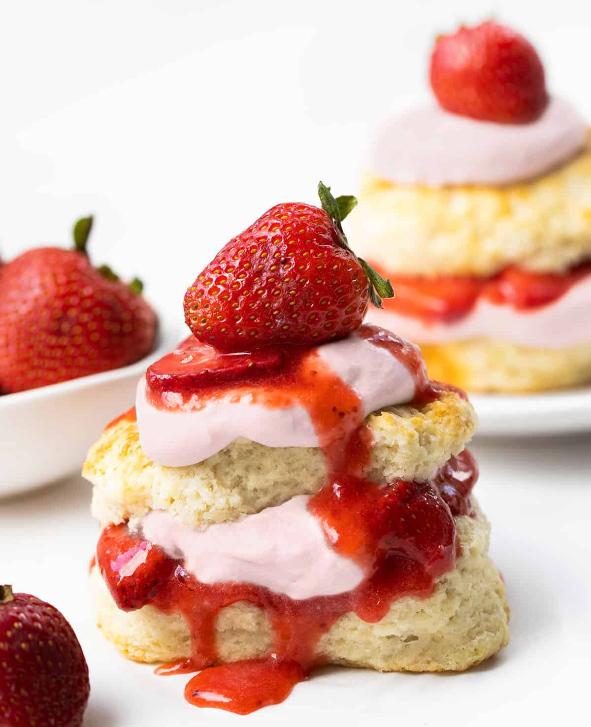 Strawberry Shortcake with Strawberry Stabilized Whipped Cream on white plates on a white table.