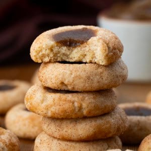 Stack of Apple Butter Thumbprint Cookies with the top cookie bitten showing inside texture.
