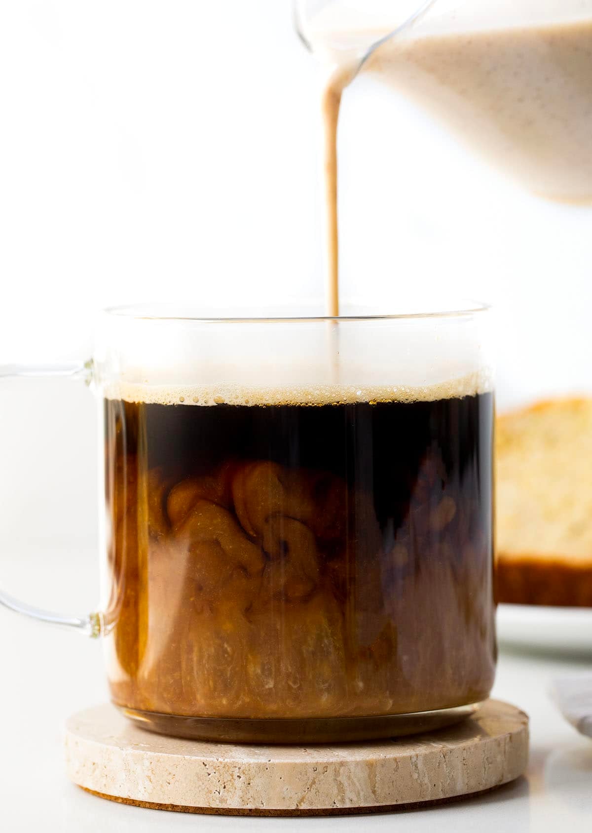 Pouring Banana Bread Coffee Creamer into a cup of coffee.