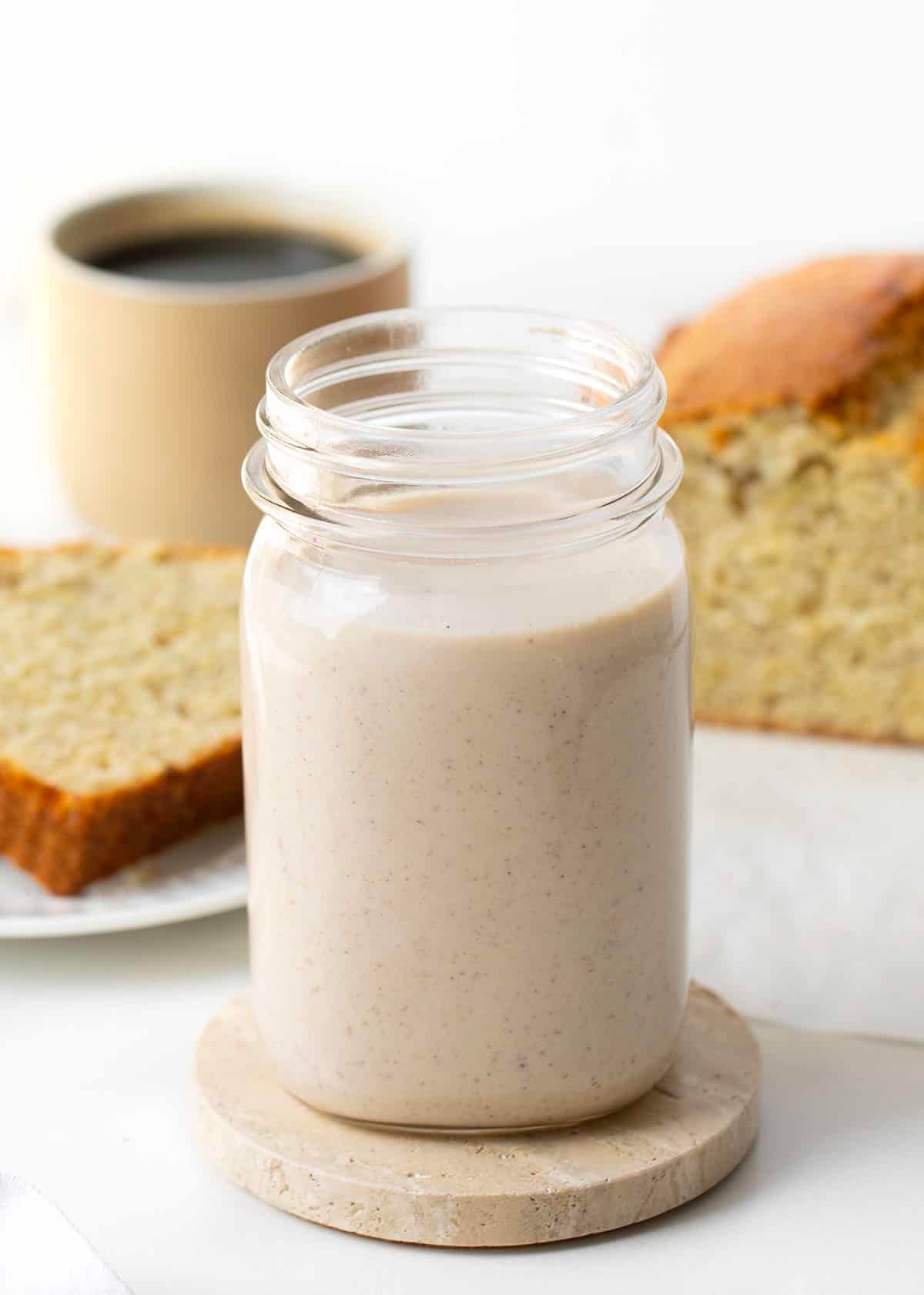 Jar of Banana Bread Coffee Creamer in front of coffee and banana bread.