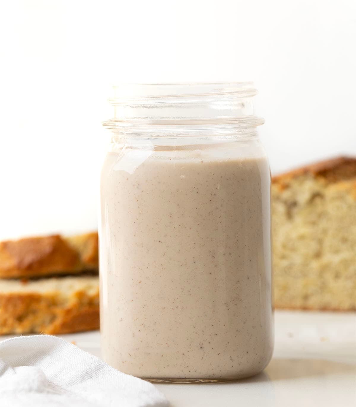 Jar of Banana Bread Coffee Creamer in front of banana bread.