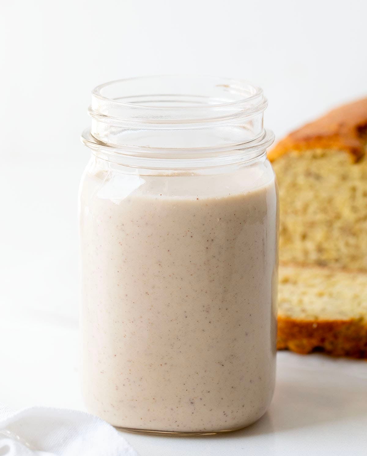 Jar of Banana Bread Coffee Creamer in front of banana bread.