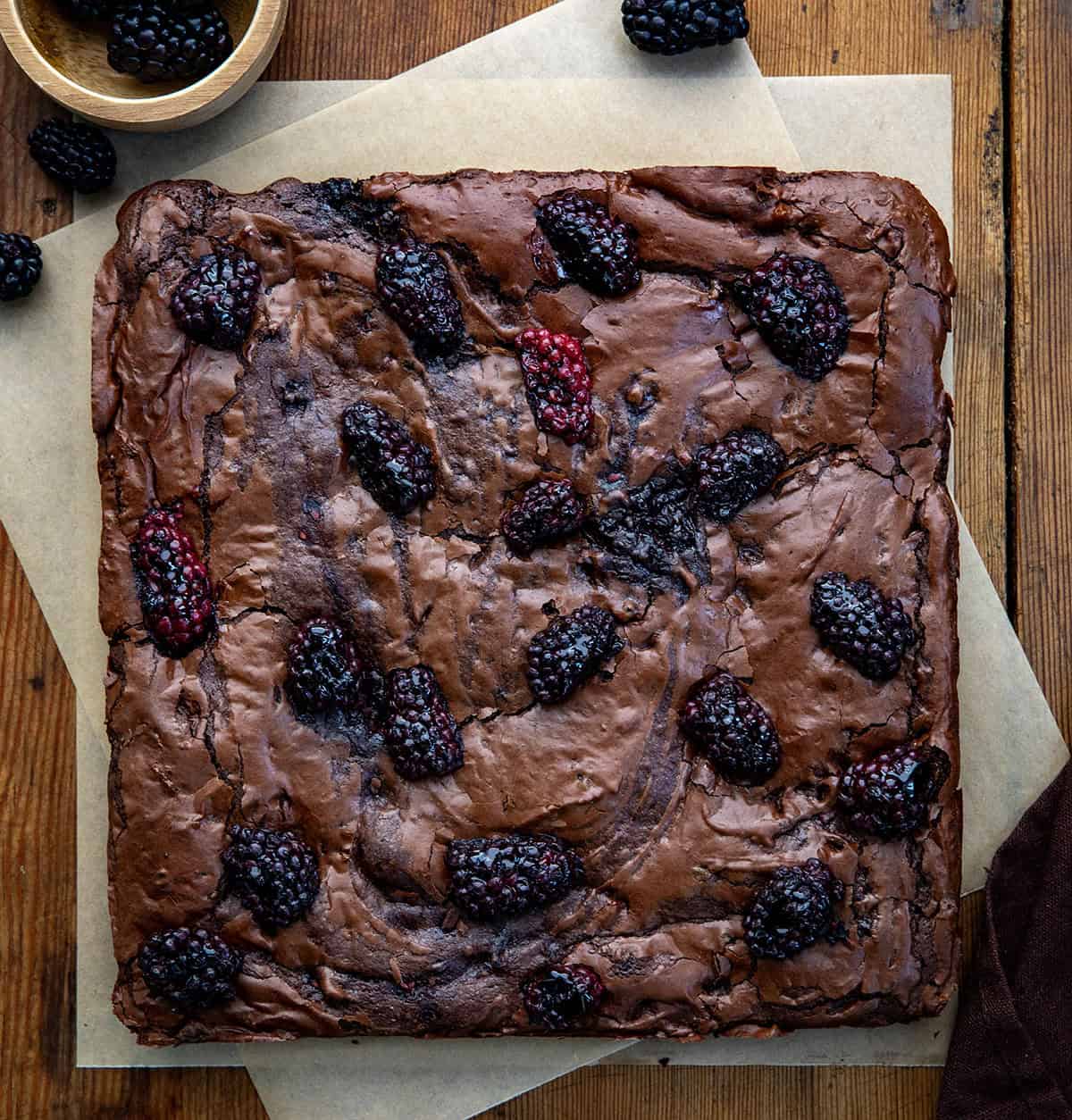 Blackberry Balsamic Brownies uncut and on a wooden table from overhead Blackberry Balsamic Brownies uncut and on a wooden table from overhead.