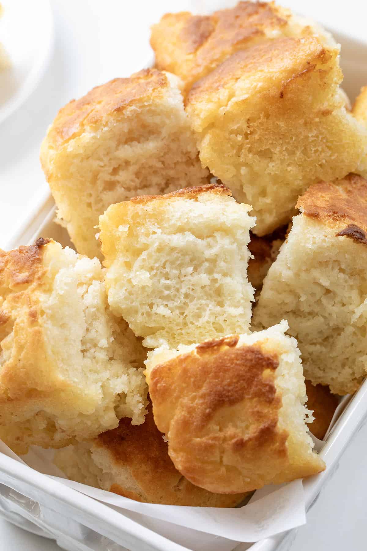 Close up of butter swim biscuits in a white basket.