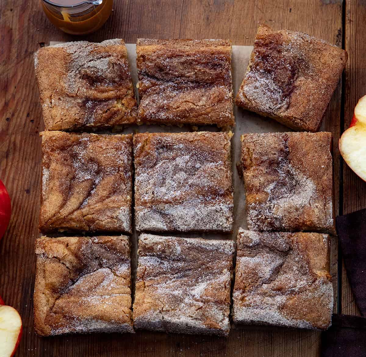 Caramel Apple Cider Blondies cut into squares on a wooden table from overhead Caramel Apple Cider Blondies cut into squares on a wooden table from overhead.