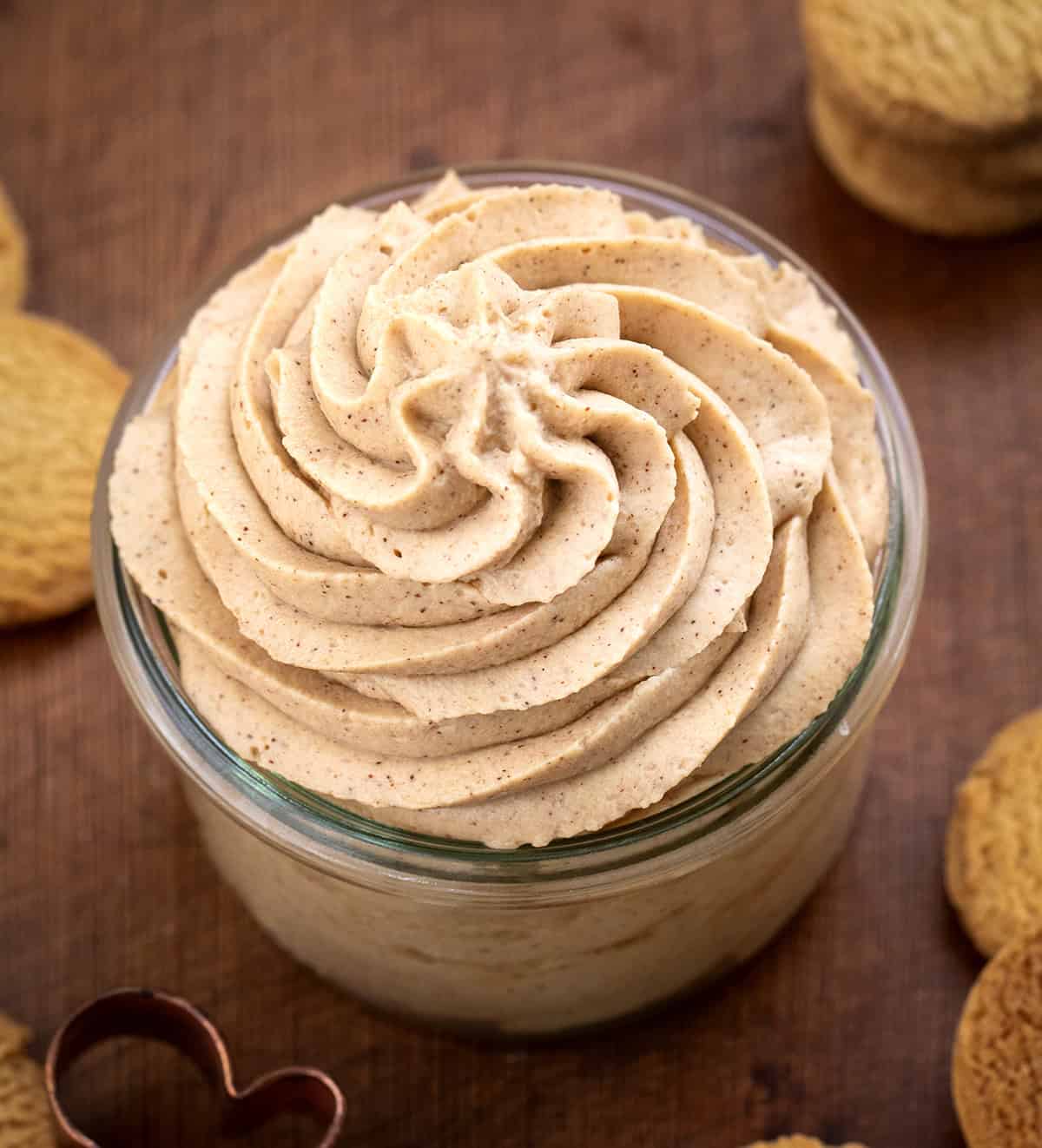 Gingerbread Stabilized Whipped Cream piped into a jar on a wooden table.