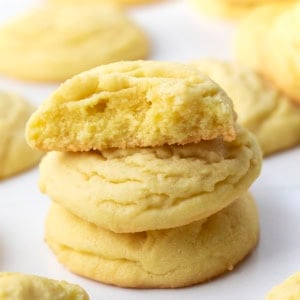 Small stack of Lemon Sugar Cookies with the top cookie broken in half showing delicate texture.