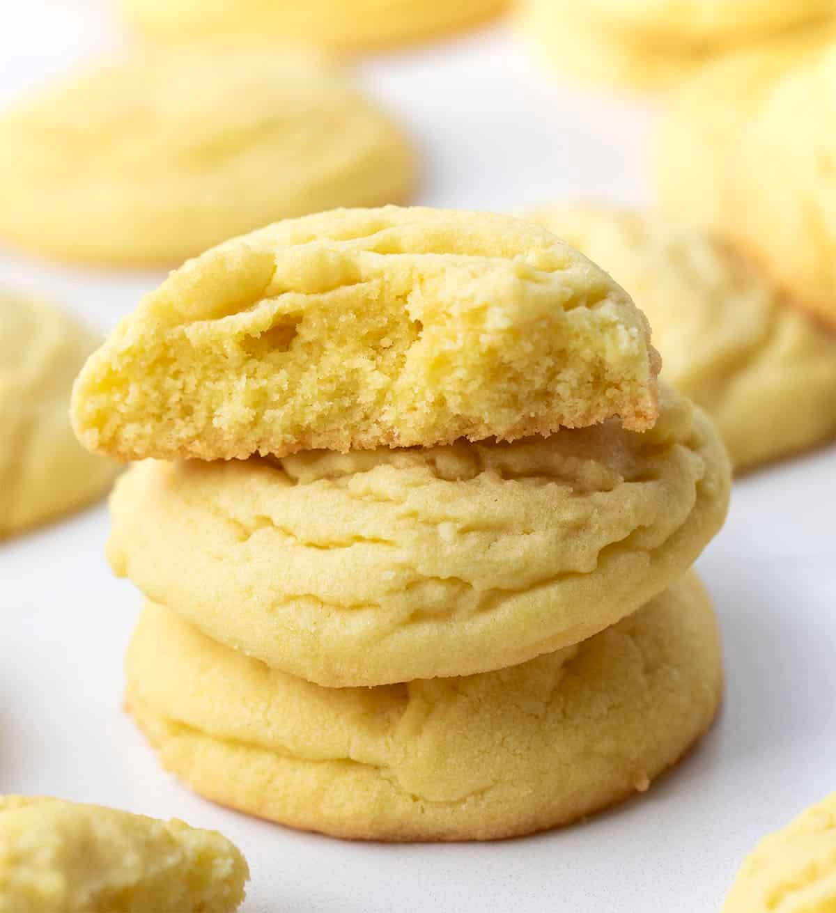 Small stack of Lemon Sugar Cookies with the top cookie broken in half showing delicate texture Small stack of Lemon Sugar Cookies with the top cookie broken in half showing delicate texture.
