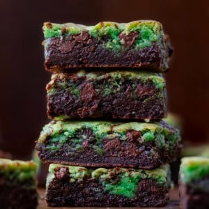 Close up of a stack of Mint Chocolate Chip Brookies on a wooden table.