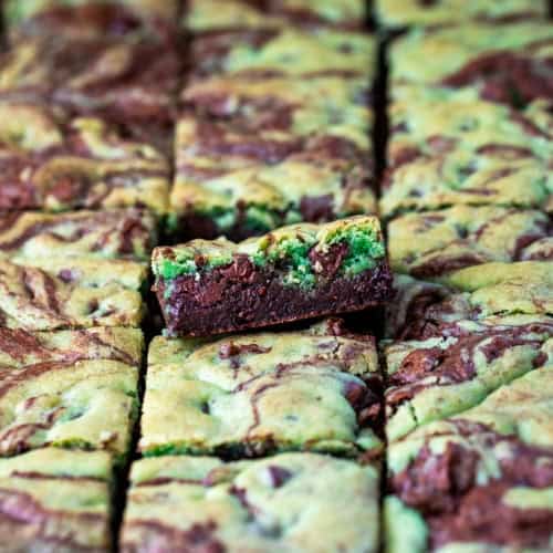 Mint Chocolate Chip Brookies cut into sqaures and all laid out with one tilted up on its edge.