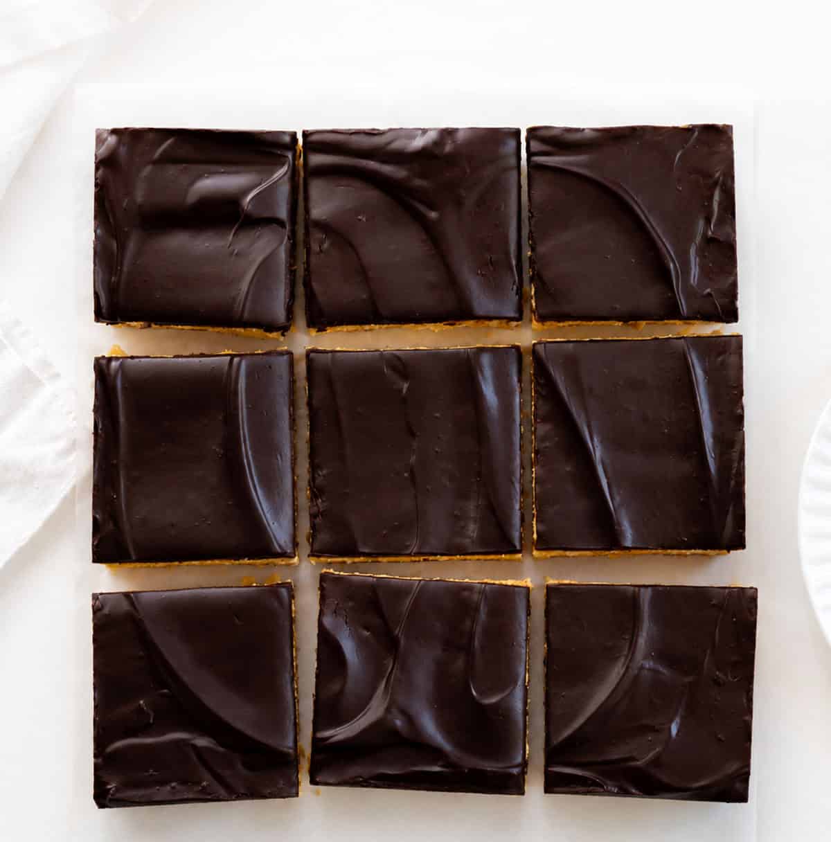 No Bake Boston Cream Pie Bars cut into squares on a white table.