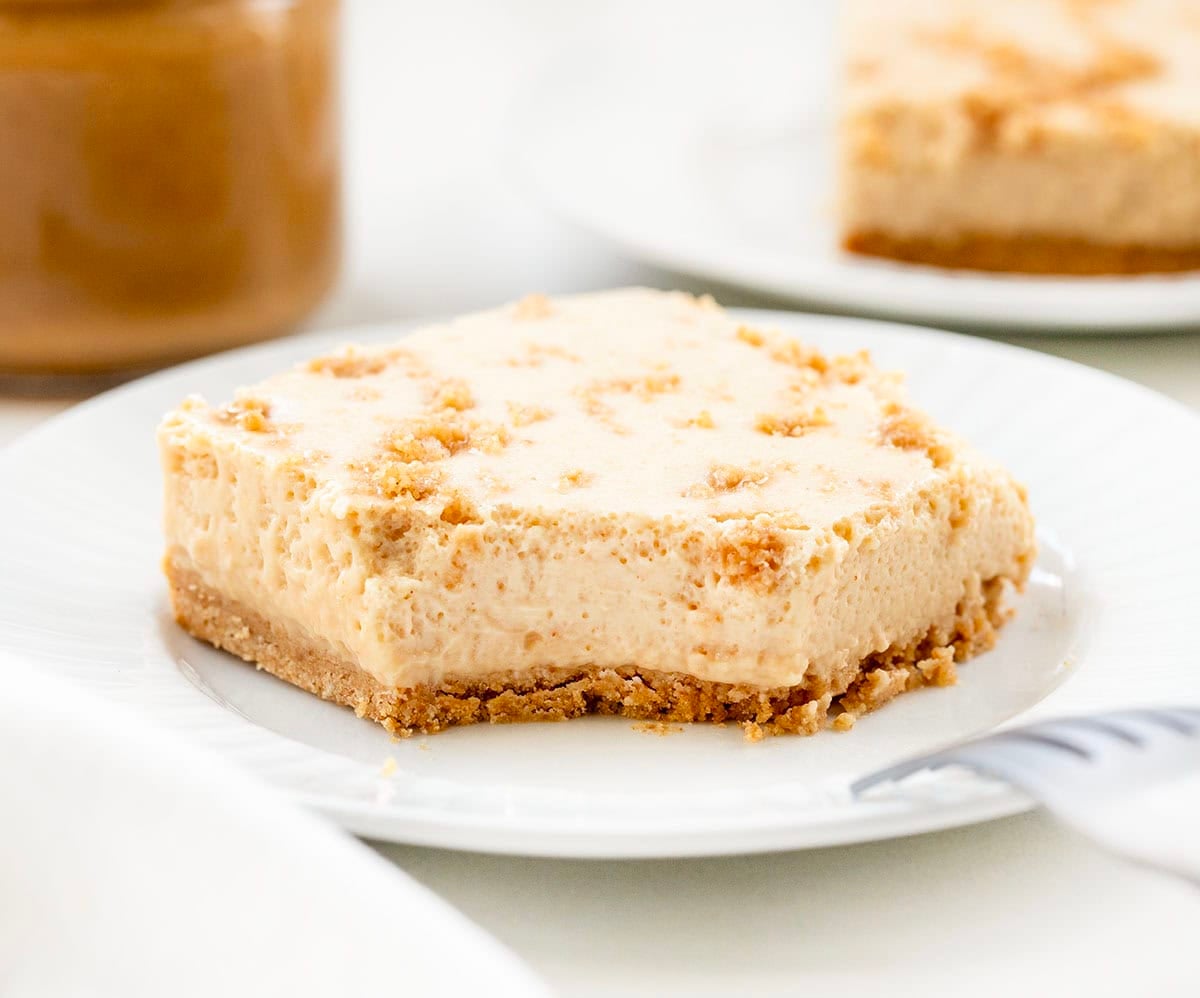 Slice of Peanut Butter Icebox Cheesecake on a white plate with a bite removed and the fork resting on the plate.