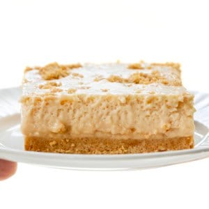 Hand holding a white plate with Peanut Butter Icebox Cheesecake on it.