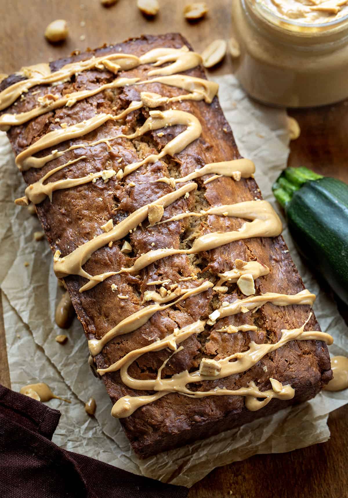 Close up of a loaf of Peanut Butter Zucchini Bread with zucchini and peanuts.