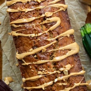 Close up of a loaf of Peanut Butter Zucchini Bread with zucchini and peanuts.