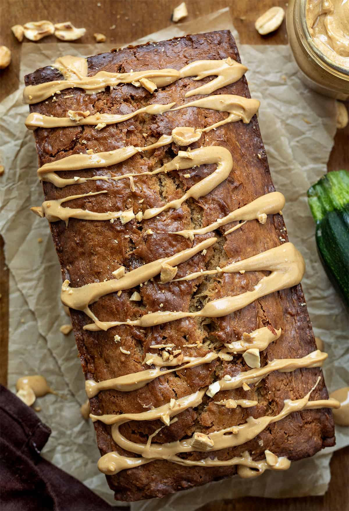 Close up of a loaf of Peanut Butter Zucchini Bread with zucchini and peanuts.