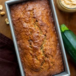 Close up of a loaf of Peanut Butter Zucchini Bread with zucchini and peanuts.