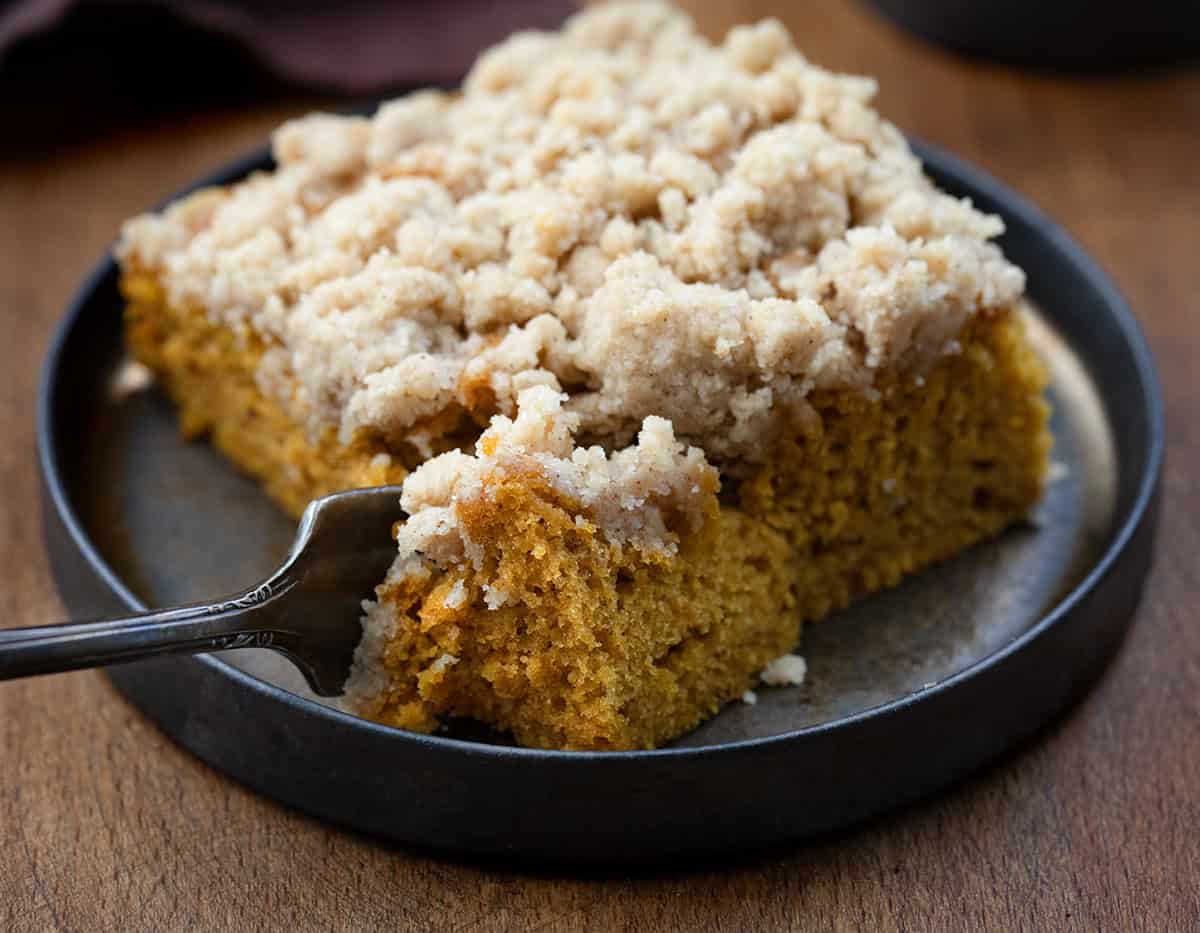 Fork taking a bite from one piece of Pumpkin Streusel Sheet Cake.