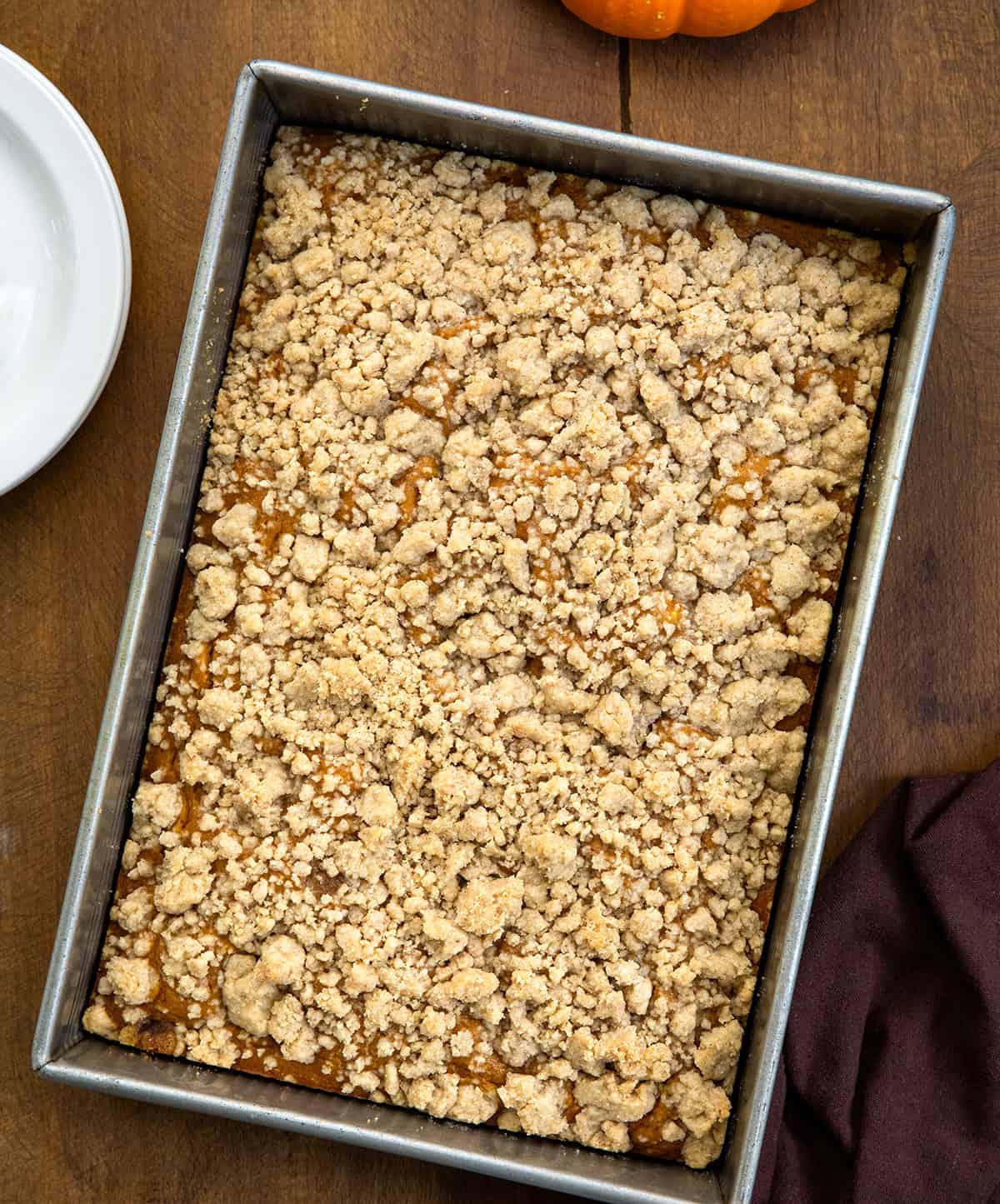 Pumpkin Streusel Sheet Cake in a metal pan on a wooden table from overhead.