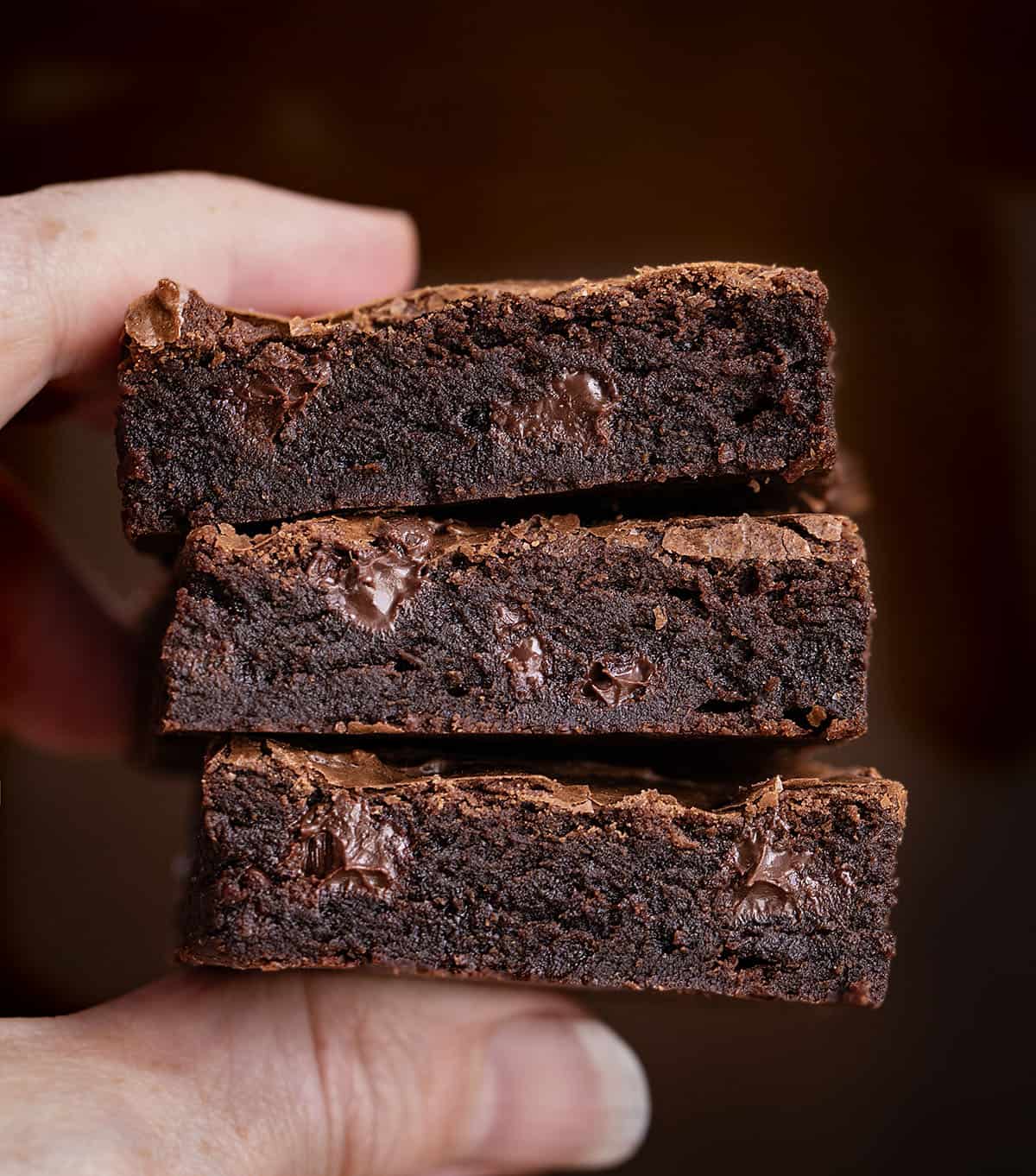 Hand holding 3 Sheet Pan Brownies close up Hand holding 3 Sheet Pan Brownies close up.