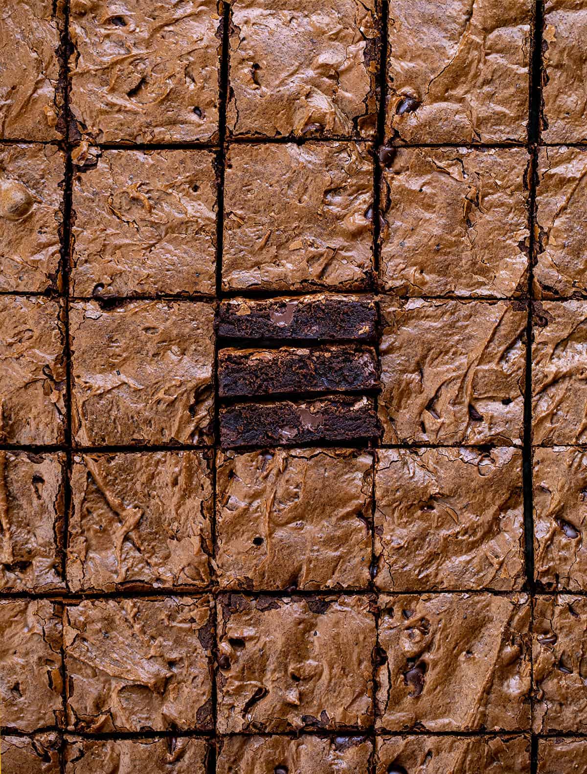 Sheet Pan Brownies cut into small squares with the center brownies on their side showing the tender texture.