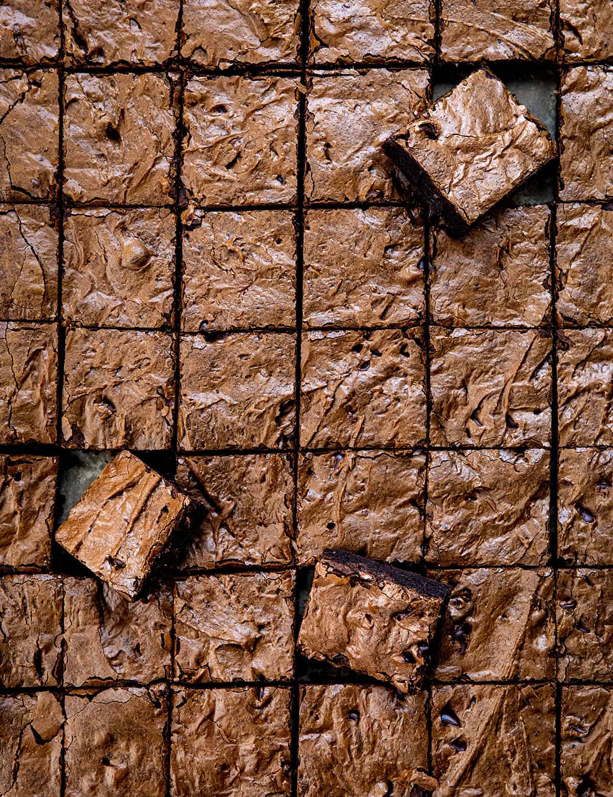 Chocolate Sheet Pan Brownies cut into small squares with some brownies at an angle Chocolate Sheet Pan Brownies cut into small squares with some brownies at an angle.
