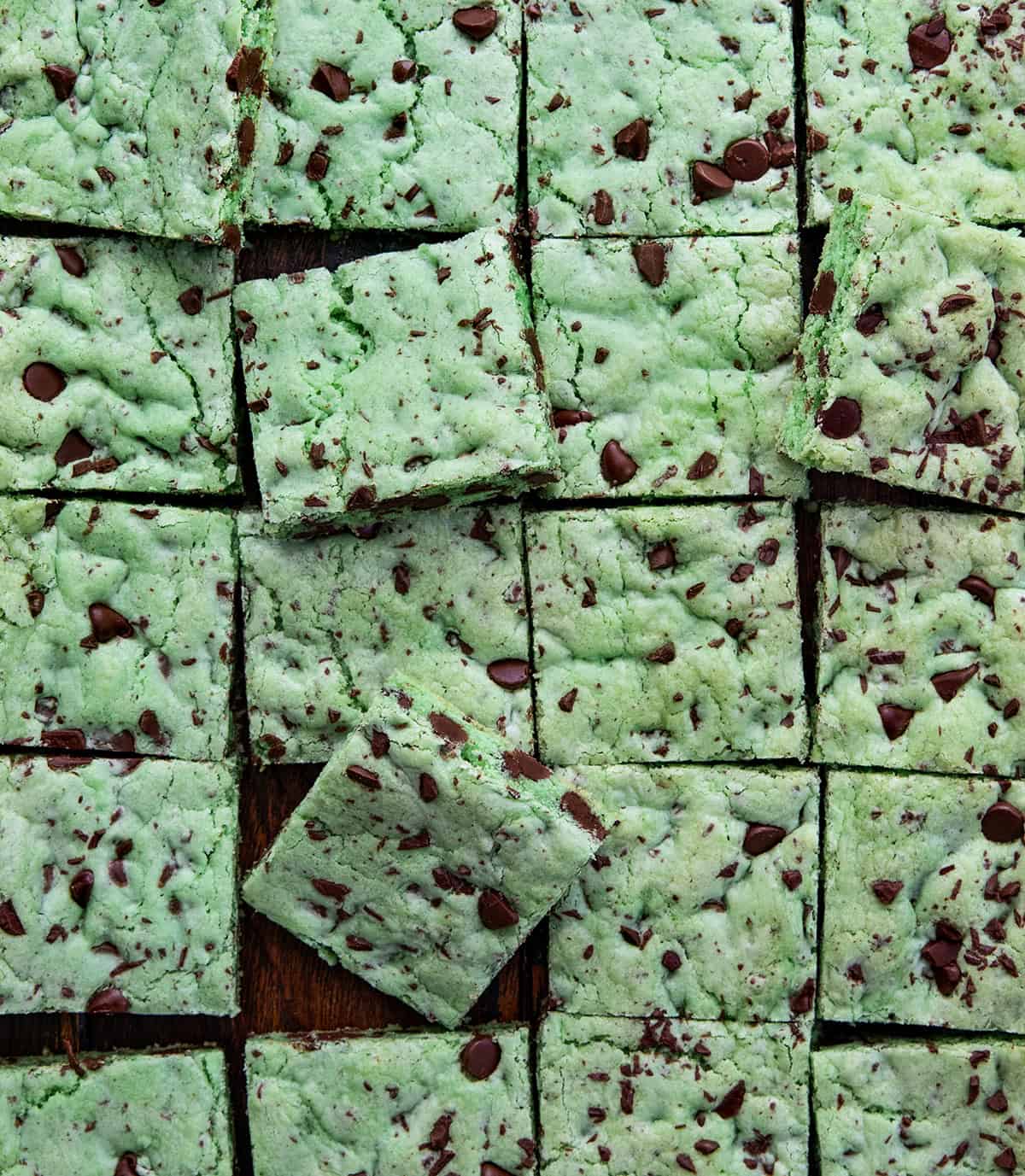 Sheet Pan Mint Chocolate Chip Cookies cut into squares close up, with some squares tilted on their sides.