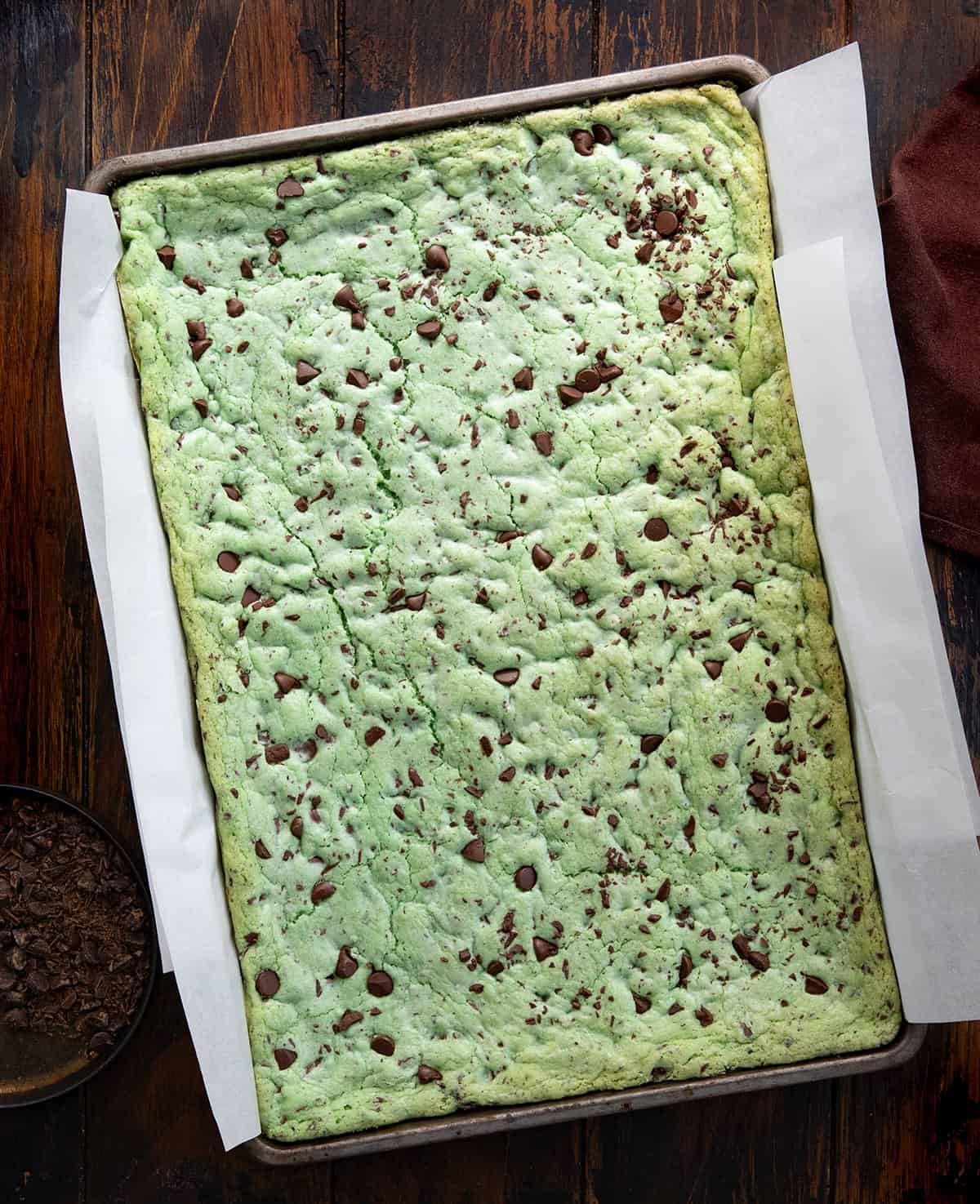 Sheet Pan Mint Chocolate Chip Cookies still in the pan on a wooden table from overhead.