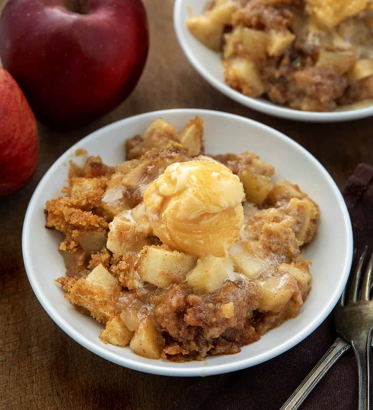 White bowls of Apple Brown Betty on a wooden table from overhead White bowls of Apple Brown Betty on a wooden table from overhead.
