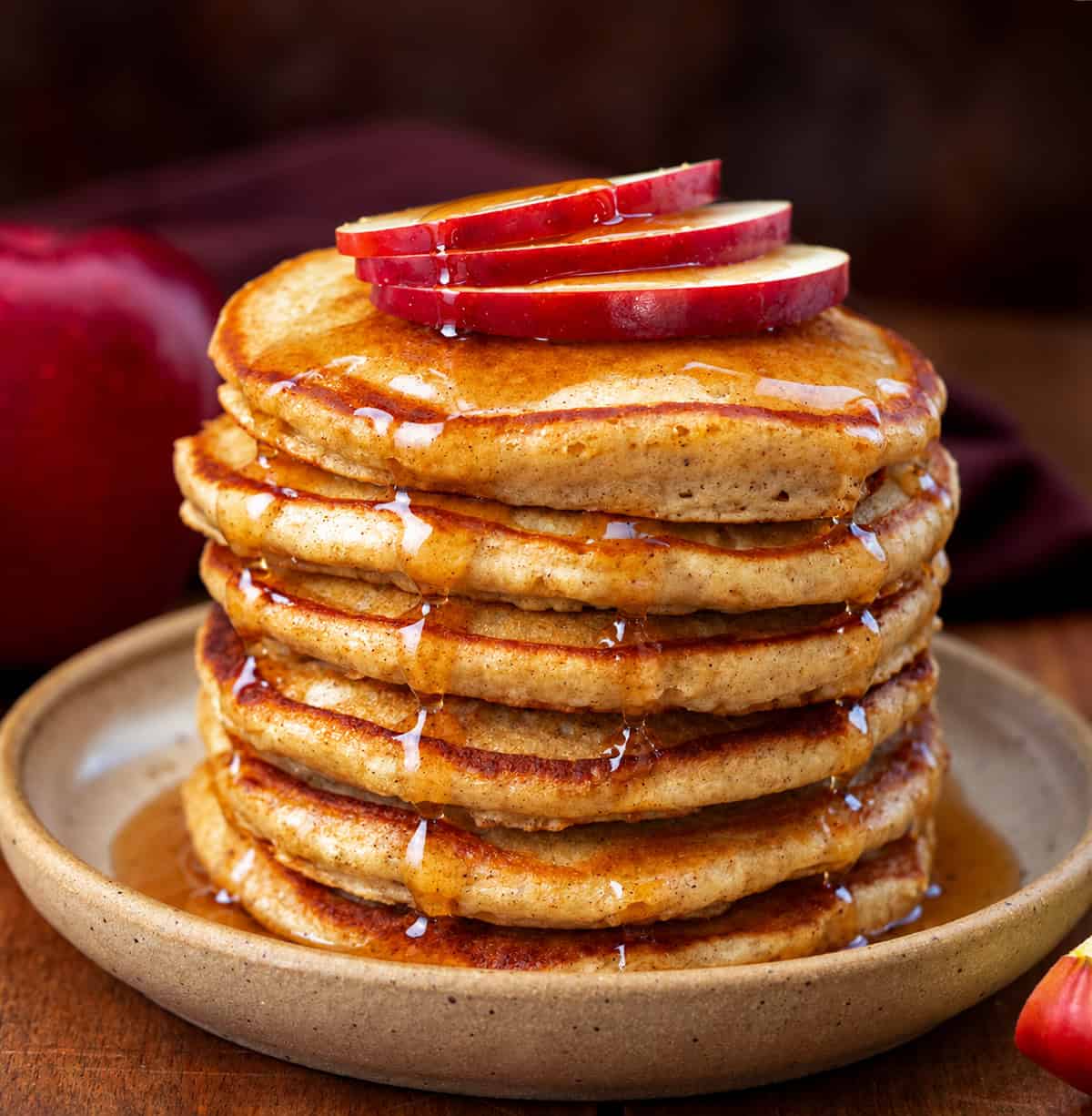 Stack of Apple Cider Pancakes with apple slices and syrup over top Stack of Apple Cider Pancakes with apple slices and syrup over top.