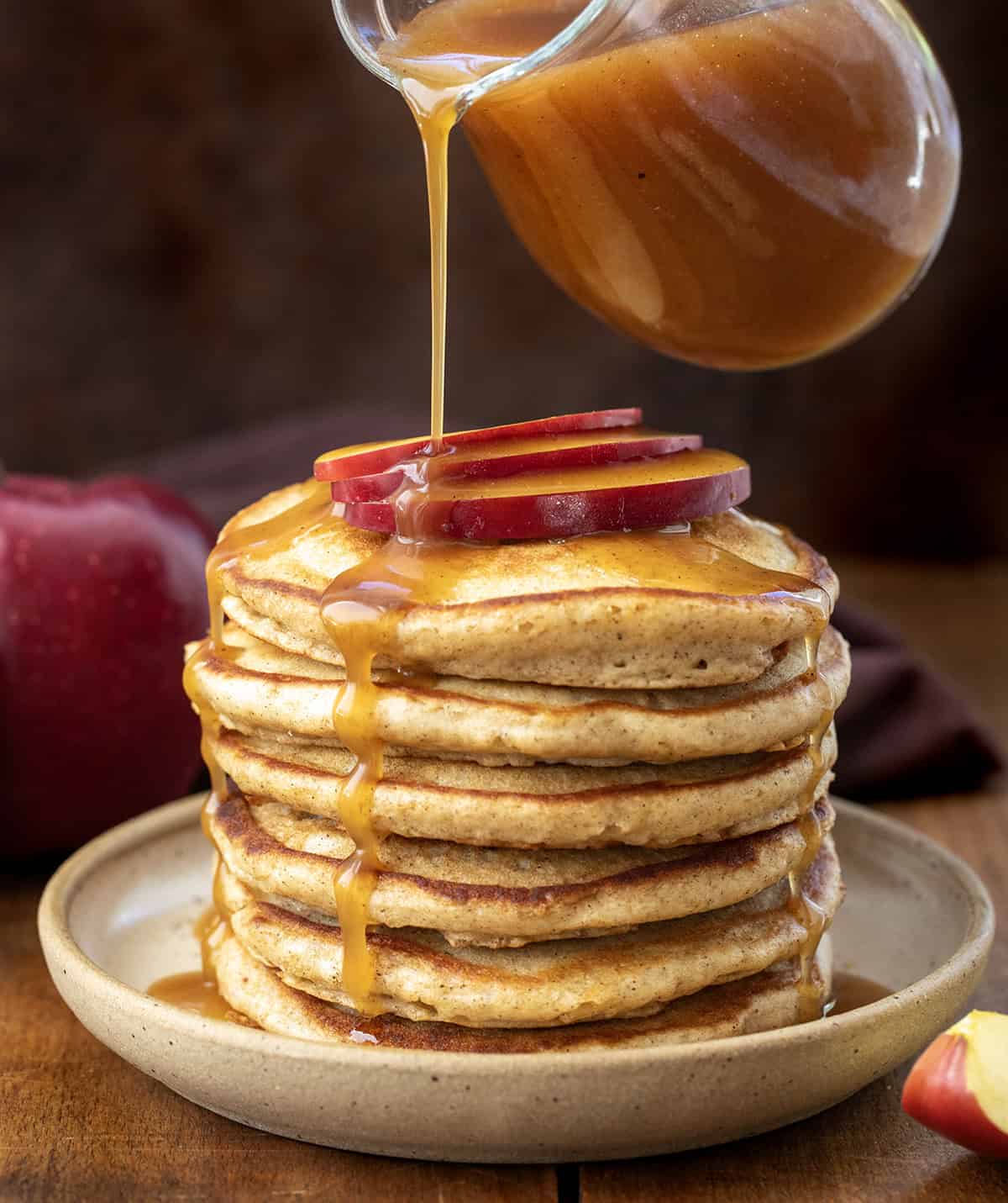 Drizzling Apple Cider Syrup over apple cider pancakes.