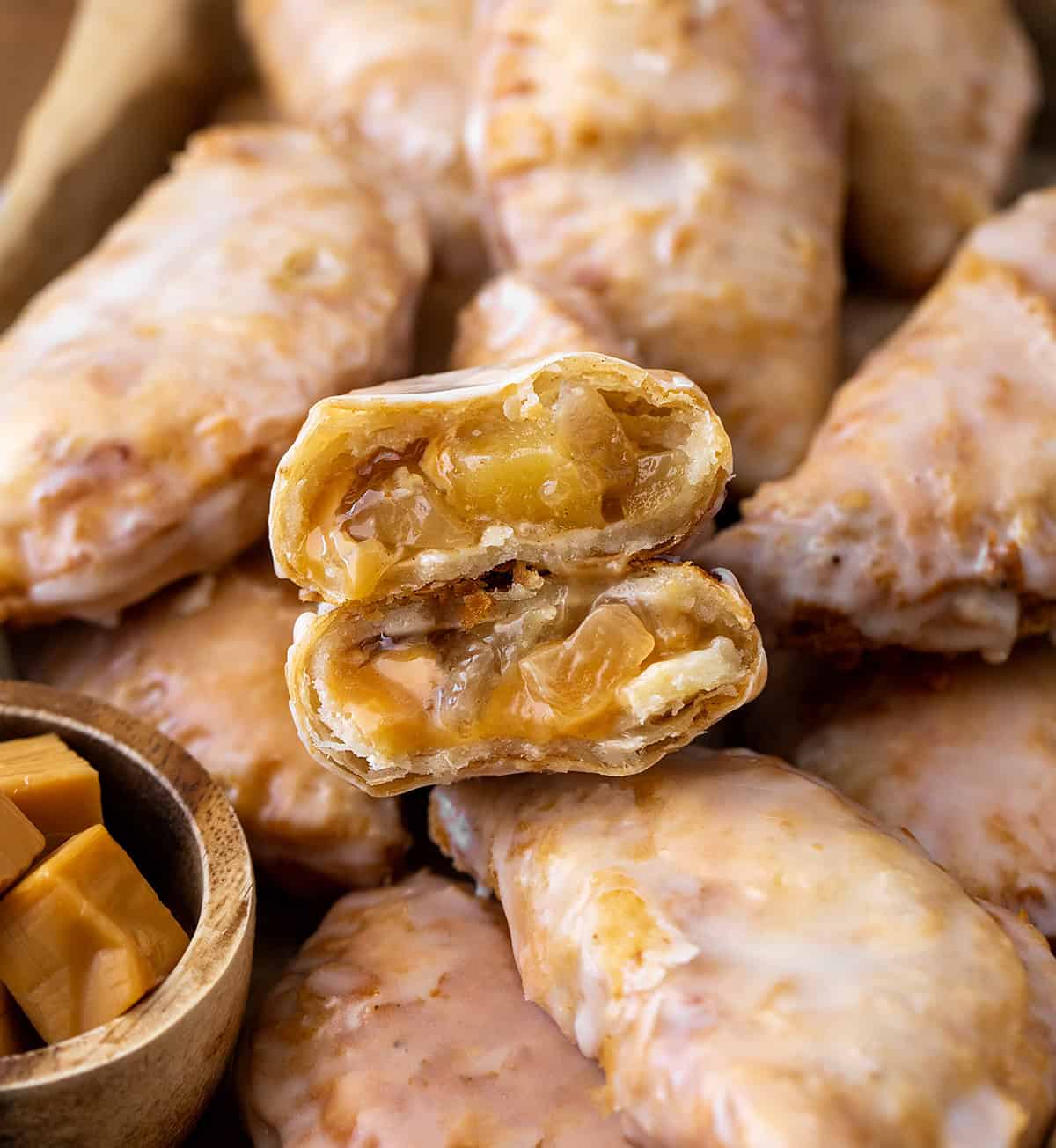 Close up of halved Caramel Apple Hand Pie surround by more hand pies.