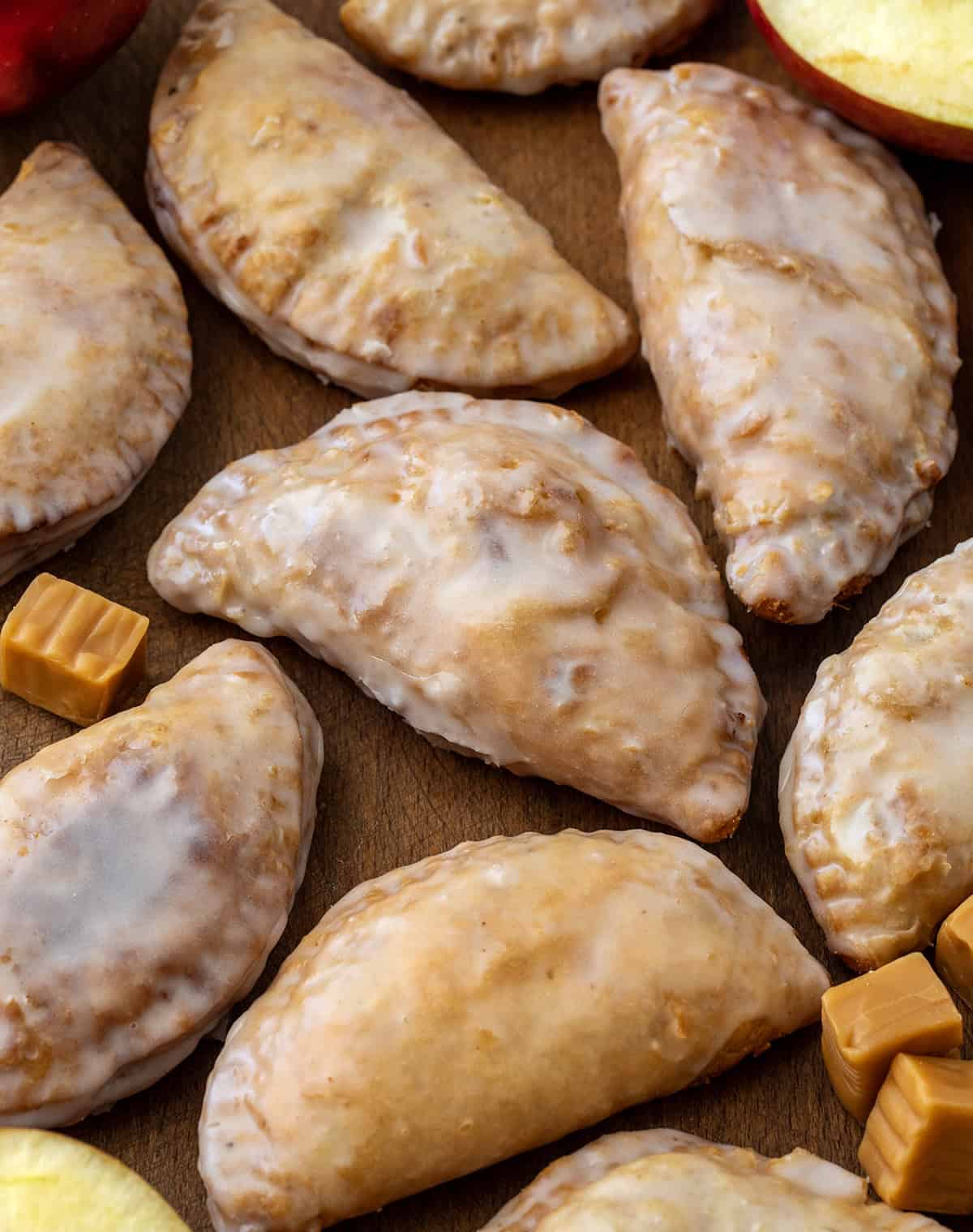 Caramel Apple Hand Pies laying flat on a wooden table from overhead.
