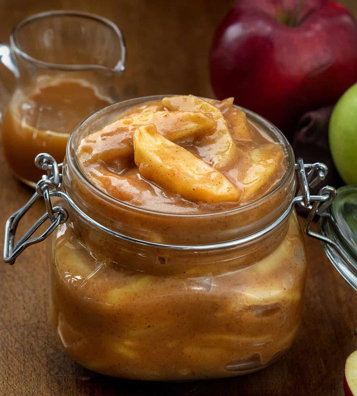 Caramel Apple Pie Filling in a jar with caramel and apples behind it Caramel Apple Pie Filling in a jar with caramel and apples behind it.