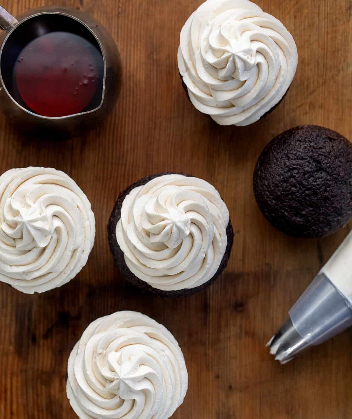 Chocolate cupcakes with Maple Ermine Frosting piped on them, a piping bar with maple ermine, and a pitcher with ermine in it Chocolate cupcakes with Maple Ermine Frosting piped on them, a piping bar with maple ermine, and a pitcher with ermine in it.
