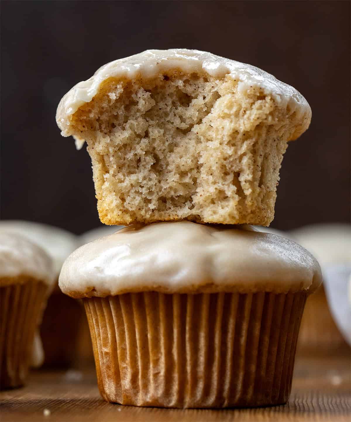 Maple Glazed Donut Muffins stacked with the top muffin halved showing the insider texture.