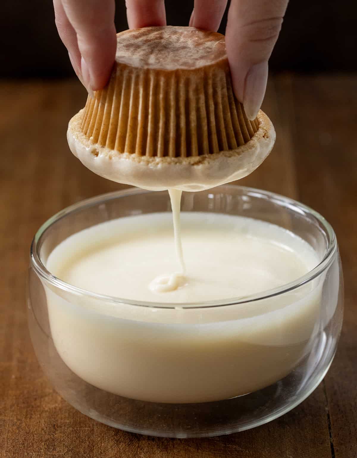 Dipping a donut muffin into maple glaze.