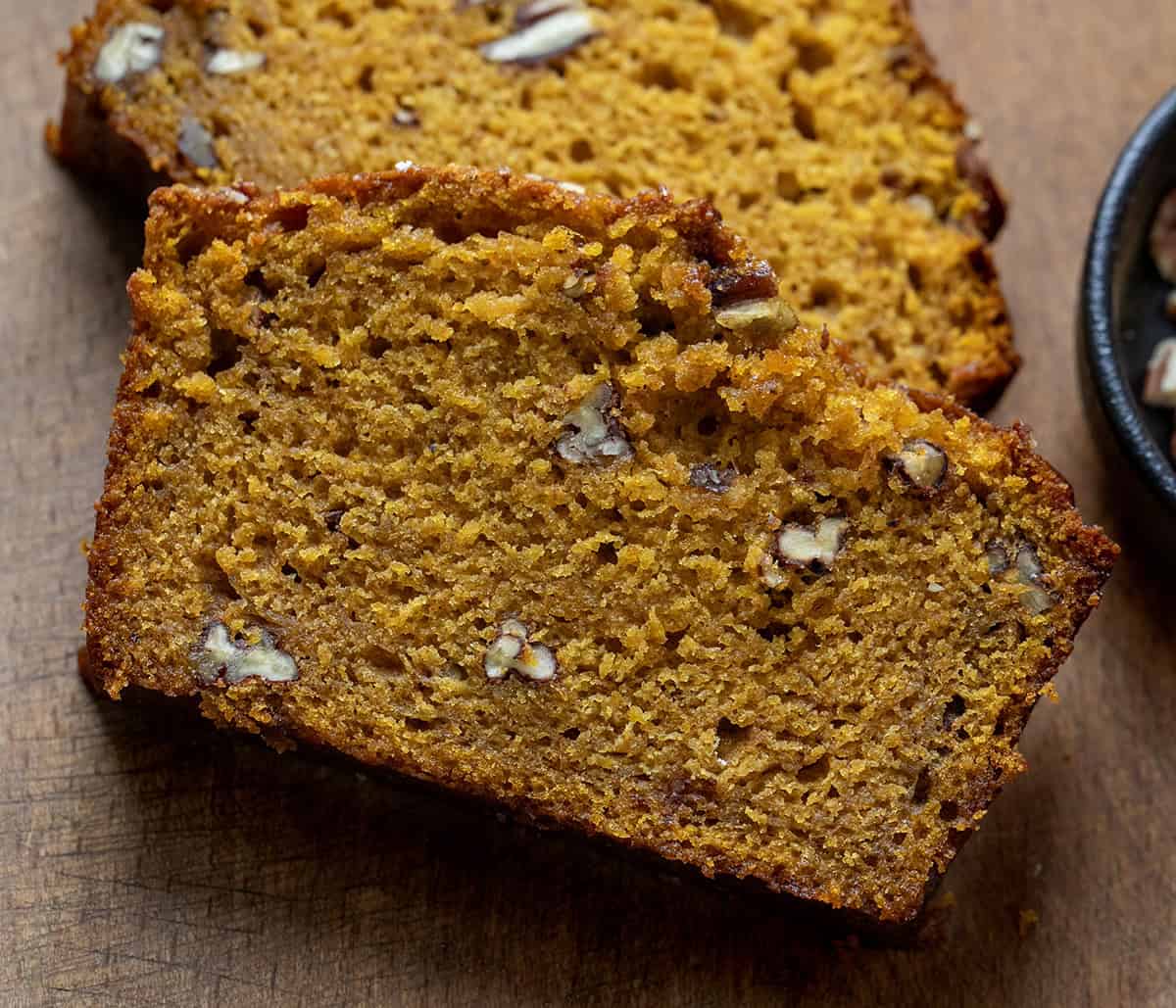 Close up of cut slices of Maple Pecan Pumpkin Bread on a wooden table Close up of cut slices of Maple Pecan Pumpkin Bread on a wooden table.