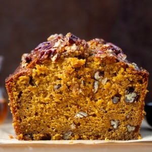 Close up of a cut loaf of Maple Pecan Pumpkin Bread showing the texture inside.