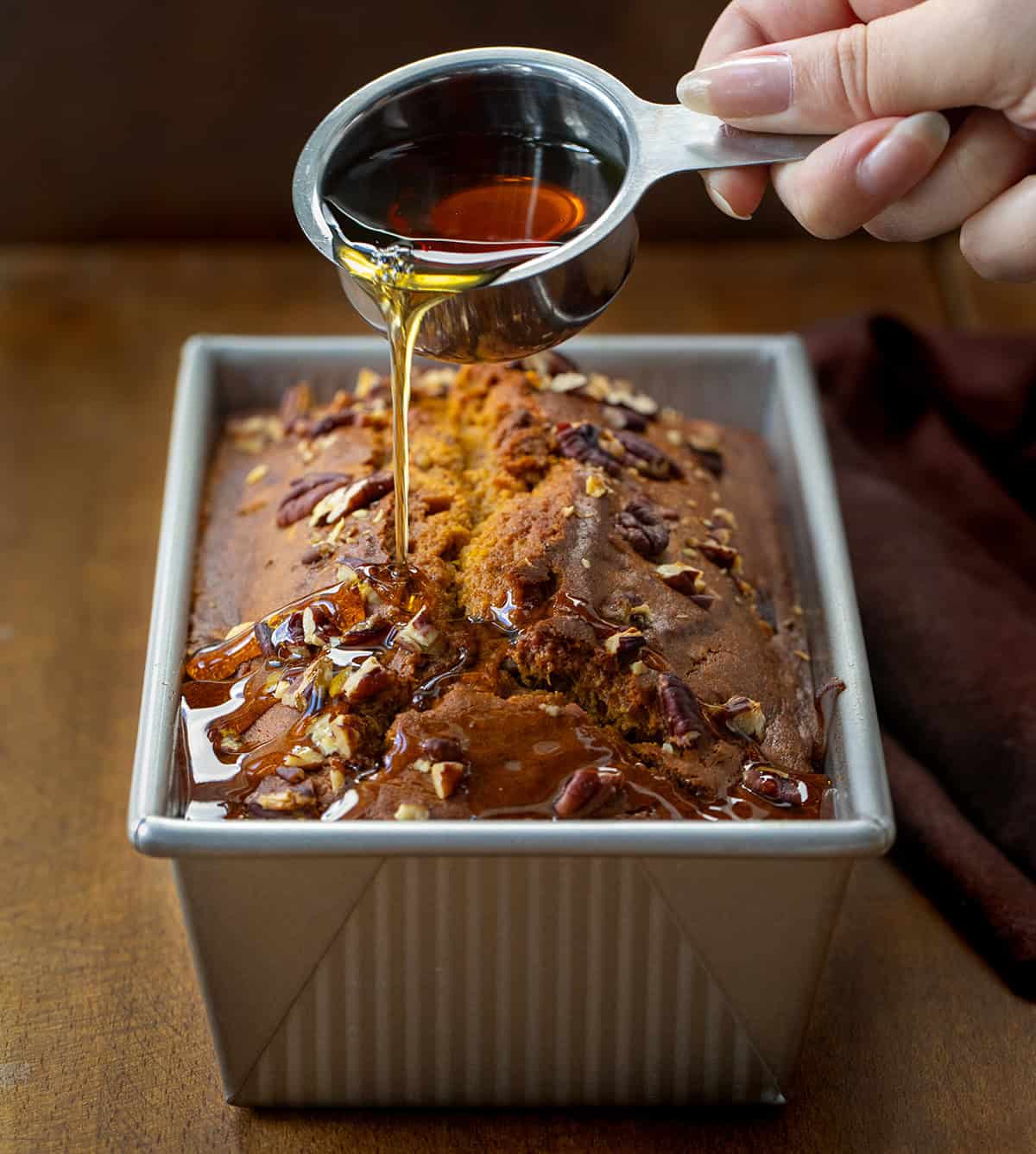 Pouring Maple Syrup over Pumpkin Pecan Bread Pouring Maple Syrup over Pumpkin Pecan Bread.