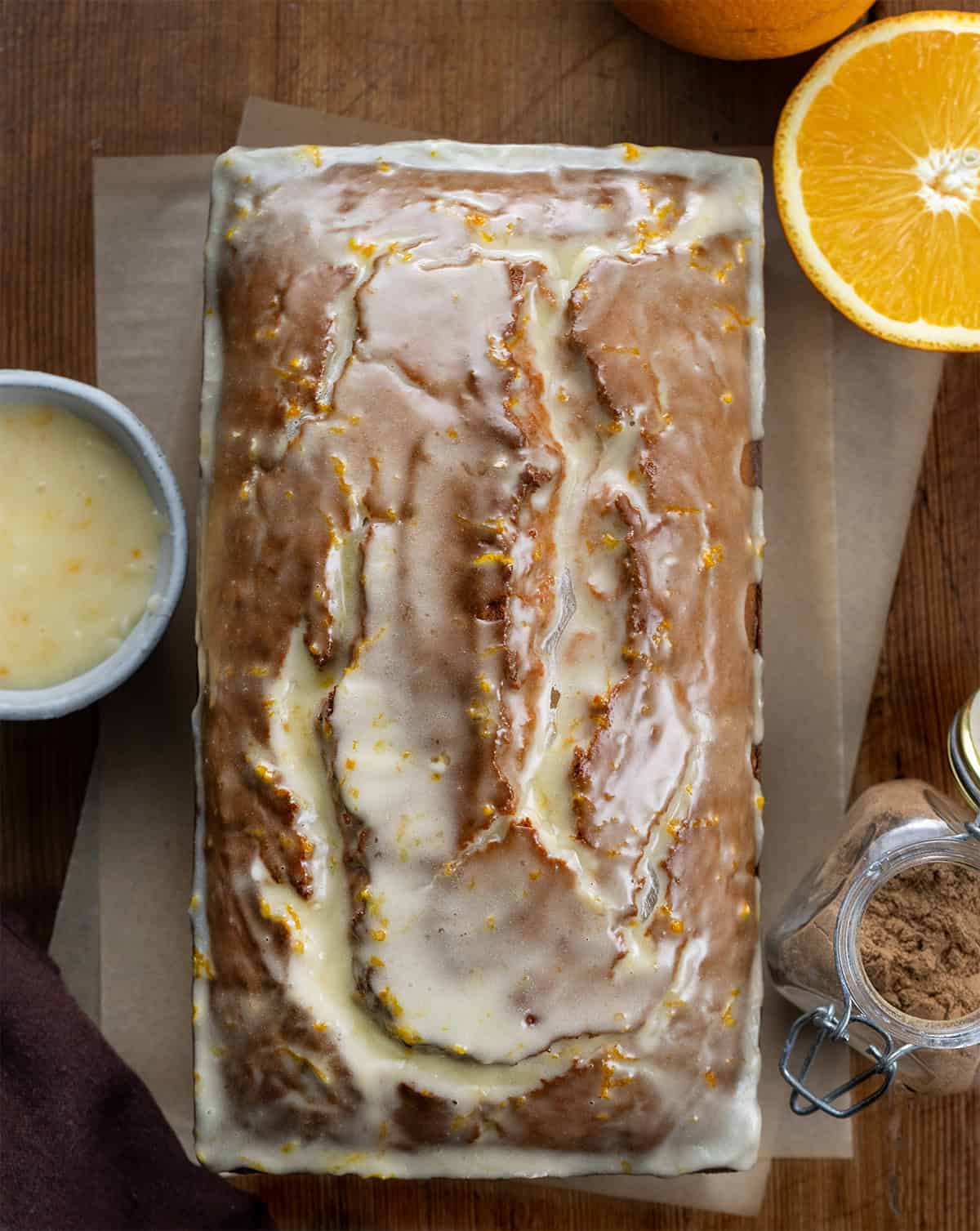 Glazed loaf of Gingerbread Bread on a wooden table from overhead.