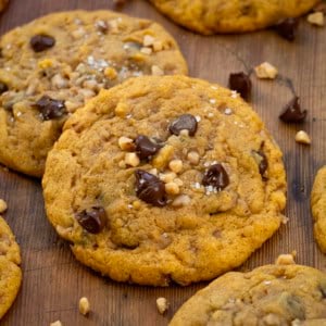 Close up of Pumpkin Toffee Chocolate Chip Cookies on a wooden table.